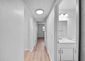 Thumbnail 4 of 16 - A long hallway with a bathroom at the end.