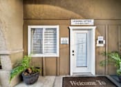 Thumbnail 3 of 16 - A leasing office with a welcome mat and a door.