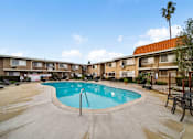 Thumbnail 5 of 16 - A swimming pool in a courtyard surrounded by apartment buildings.