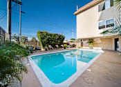 Thumbnail 3 of 15 - A small pool in a backyard with a house in the background.