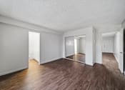 Thumbnail 13 of 18 - A room with wooden floors and white walls.