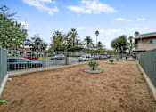 Thumbnail 3 of 18 - A dirt area with a fence and a tree in the middle.