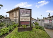 Thumbnail 1 of 18 - A sign for the Royal Garden Apartments stands in front of a building.