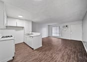 Thumbnail 15 of 18 - A kitchen with white appliances and wooden floors.