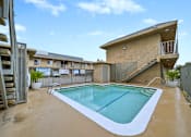 Thumbnail 9 of 18 - A small pool in a backyard with a staircase leading to a balcony.
