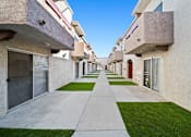 Thumbnail 9 of 10 - A long concrete walkway separates apartment buildings.