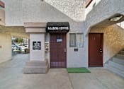 Thumbnail 8 of 10 - The leasing center has a brown door and a green mat in front of it.