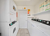 Thumbnail 10 of 10 - A white laundry room with a washer and dryer.