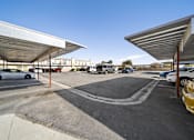Thumbnail 6 of 10 - A parking lot with cars parked under a metal roof.