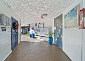 Thumbnail 8 of 11 - A hallway with a blue trash can and a red fire extinguisher on the wall.