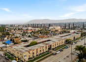 Thumbnail 8 of 8 - A cityscape with buildings, cars, and a mountain in the distance.