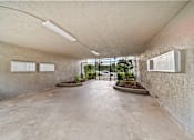 Thumbnail 4 of 8 - A concrete room with a planter and two white boards on the wall.
