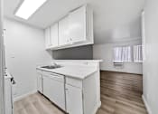 Thumbnail 7 of 10 - A kitchen with white cabinets and a white counter top.