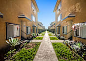 Thumbnail 4 of 10 - A row of houses with a concrete walkway between them.