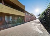 Thumbnail 6 of 10 - A sunny day in a quiet residential street with apartment buildings on either side.