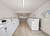 Thumbnail 10 of 10 - A laundromat with rows of washers and dryers.