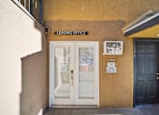 Thumbnail 9 of 10 - A leasing office is located in a building with a white door and a sign above it.
