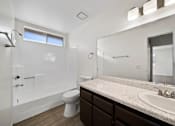 Thumbnail 12 of 16 - A white bathroom with a toilet, sink, and mirror.
