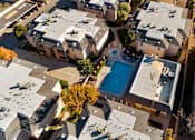 Thumbnail 2 of 16 - A bird's eye view of a residential area with a swimming pool.