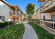Thumbnail 3 of 16 - A pathway leads between two buildings with balconies.