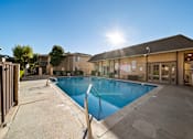 Thumbnail 7 of 16 - A sunny day at the pool with a building in the background.