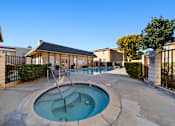 Thumbnail 5 of 16 - A hot tub sits in the middle of a patio.