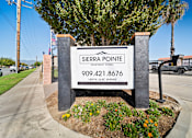 Thumbnail 2 of 6 - A sign for Sierra Pointe Apartment Homes stands in front of a tree.