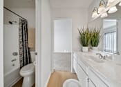 Thumbnail 13 of 16 - A white bathroom with a toilet, sink, and mirror.
