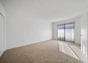 Thumbnail 11 of 16 - A room with a carpeted floor and a window with blinds.