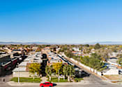 Thumbnail 3 of 16 - A red car is parked on the side of a road in a suburban area.