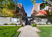 Thumbnail 2 of 16 - A building with a gate in the middle of a pathway.