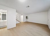 Thumbnail 5 of 16 - A room with wooden floors and white walls.