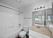 Thumbnail 13 of 20 - A white bathroom with a toilet, sink, and bathtub.