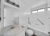 Thumbnail 15 of 20 - A white bathroom with a sink, toilet and bathtub.