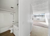 Thumbnail 6 of 8 - A white bathroom with a toilet, sink, and bathtub.