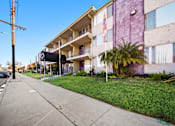 Thumbnail 2 of 8 - A purple building with a flag on the balcony.
