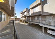 Thumbnail 2 of 4 - A car is parked in a parking lot between two buildings.
