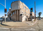 Thumbnail 1 of 4 - A street corner with a traffic light and a building.