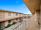 Thumbnail 9 of 17 - A long balcony with stairs leading to apartment buildings.