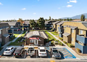 Thumbnail 2 of 13 - A sunny day in a residential area with cars parked in a row.