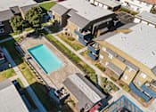Thumbnail 4 of 13 - A swimming pool is surrounded by houses.