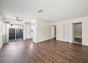 Thumbnail 6 of 13 - A room with wooden floors and white walls.