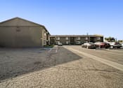 Thumbnail 8 of 9 - A parking lot with a building in the background.