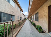 Thumbnail 6 of 15 - A long, narrow walkway separates apartment buildings.