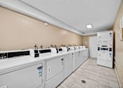 Thumbnail 15 of 15 - A row of washing machines in a laundry room.