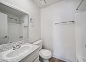 Thumbnail 8 of 9 - A white bathroom with a sink, toilet, and bathtub.