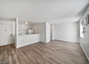 Thumbnail 7 of 9 - A room with wooden flooring and white walls.