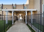 Thumbnail 1 of 9 - A long concrete walkway leads to a building with the number 15234 on it.