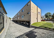 Thumbnail 7 of 9 - A long building with a car parked in front of it.