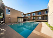 Thumbnail 5 of 9 - A swimming pool in a courtyard surrounded by buildings.